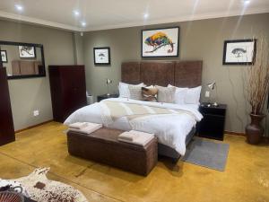 1 dormitorio con 1 cama grande y 1 reposapiés en Mountain Dew Quest House, en Noordkaap