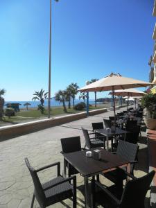 a patio with tables and chairs and an umbrella at Rincón Sol in Rincón de la Victoria