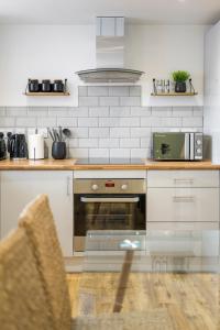 a kitchen with a stove and a microwave at Modern 4 bed & 4 En-suite City Centre with Parking in Southampton