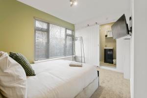 a bedroom with a large white bed and a television at Modern 4 bed & 4 En-suite City Centre with Parking in Southampton