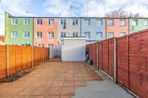 a fence with a white door in front of a building at Modern 4 bed & 4 En-suite City Centre with Parking in Southampton