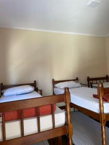 a room with three beds in a room at Hostel Fratelli Costa in Delfinópolis +4 photos