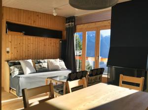 a bedroom with a bed and a table and chairs at Leysin Lodge in Leysin