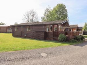a log cabin with a porch and a yard at Our Happy Place in Carnforth
