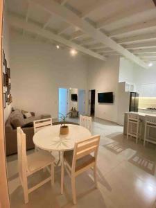 Casa de frente para lagoa com vista deslumbrante e ambiente tranquilo في لاغونا: غرفة طعام وغرفة معيشة مع طاولة وكراسي