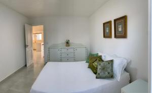 Casa de frente para lagoa com vista deslumbrante e ambiente tranquilo في لاغونا: غرفة نوم بيضاء مع سرير أبيض وخزانة