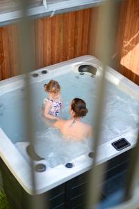 a woman and a little girl in a hot tub at Maison de charme avec Jacuzzi in Vouvray