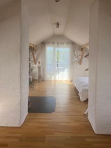a white bedroom with a bed and a window at Ferienappartements REST - inkl. Chiemgau-Karte in Siegsdorf