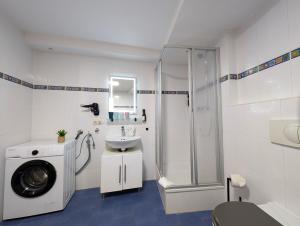 a white bathroom with a shower and a sink at BohnApartments - Am Theater- WLAN- Terrasse- City - Vollausstattung in Erfurt