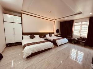 a bedroom with two beds and a large screen at Peaceful Mountain Hotel in Ha Giang