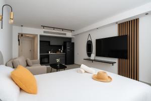 a bedroom with a white bed with a flat screen tv at סי סייד אילת חדר משפחתי מפנק עם נוף לים in Eilat