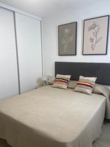 a bedroom with a bed with two pillows on it at Homu Sunset - Apartamento cerca de la playa in Arguineguín