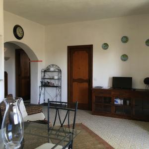salon ze szklanym stołem i zegarem na ścianie w obiekcie Villa Baia del Riccio w mieście Agnone Bagni