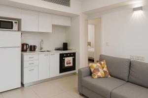 Una sala de estar con un sofá y una cocina. en סי סייד אילת סוויטה יוקרתית מפנקת 3 חדרים מרחק הליכה מהים, en Eilat