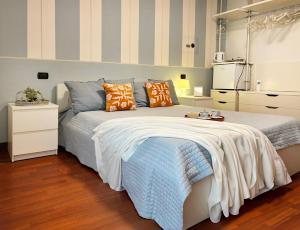 a bedroom with a large bed with orange and blue pillows at Holihome - La Suite dei Fiori in San Benedetto del Tronto