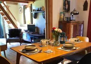 a dining room table with plates and flowers on it at Eco-friendly Cornish sanctuary in Penzance