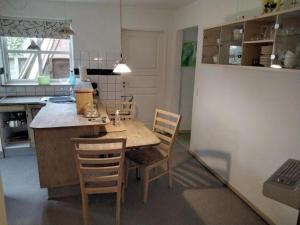 a kitchen with a wooden table and chairs at Bed and Breakfast Filskov in Filskov