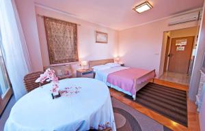 a hotel room with two beds and a table at Green Sea Villa - Wild Orange Dubrovnik in Zaton