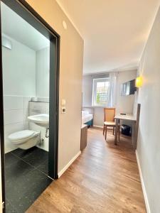 un baño con inodoro y lavabo en AR Boutique Hotel Heusenstamm, en Heusenstamm 68 fotos más