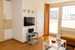 a living room with a couch and a tv on a wall at Lord Nelson 115 in Döse