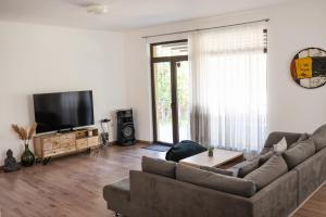 a living room with a couch and a flat screen tv at Вила Маунтайн Вю in Brestnik