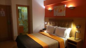 a hotel room with a bed with two pillows at Hotel Dom João Lisboa in Lisbon