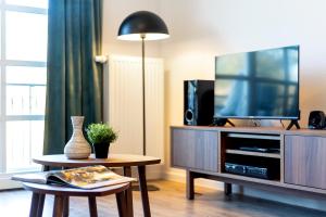 a living room with a tv and a table at Residenz am Balmer See - BS 55 mit Wellnessbereich in Balm