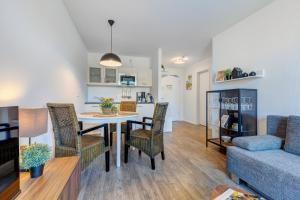 a living room and kitchen with a table and chairs at Residenz am Balmer See - BS 55 mit Wellnessbereich in Balm