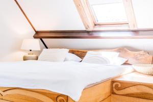 a bedroom with a wooden bed with a window at "Albatros" Knus huisje op Texel in De Koog