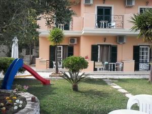 a pink house with a playground in front of it at RoyalRose in Paleokastritsa