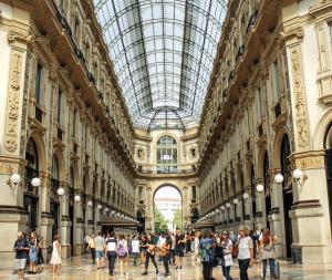 a group of people walking in a building with a glass ceiling at 10' from Malpensa & transfert on demand in Casorate Sempione
