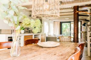 a dining room table with a vase of flowers on it at "Albatros" Knus huisje op Texel in De Koog