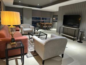 a living room with furniture and a flat screen tv at One Constitution Avenue by Goldfinch, Luxury apartments near Diplomatic Enclave and Serena in Islamabad