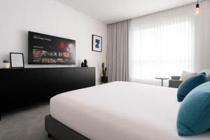 a bedroom with a bed and a flat screen tv at סי סייד אילת חדר משפחתי מפנק עם נוף לים in Eilat