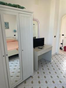 a bedroom with a mirror and a desk with a computer at Casa La Perla in Ischia