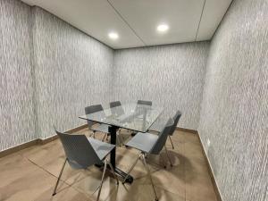 a conference room with a glass table and chairs at New Cozy and Modern Gym Coworking Terrace in Bogotá