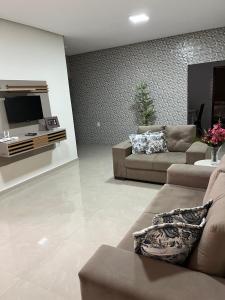 a living room with a couch and a tv at Casa de temporada da vó zelina in Piranhas