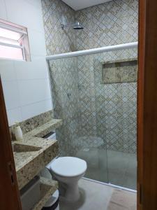 a bathroom with a toilet and a glass shower at Casa de temporada da vó zelina in Piranhas +3 photos