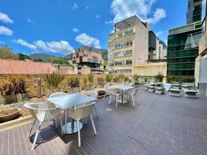 a patio with tables and chairs and buildings at New Cozy and Modern Gym Coworking Terrace in Bogotá