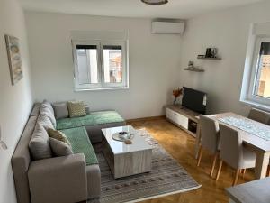 a living room with a couch and a table at Apartman Stević in Vrnjci +8 photos