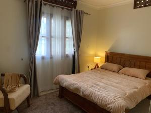 a bedroom with a large bed and a window at The Cozy Retreat, Warm & Inviting in Kampala