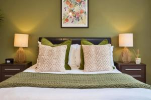 a bedroom with a bed with green walls and two lamps at NEW Greydawn House - Stunning 4 Bedroom House in Stoke-on-Trent in Stoke on Trent