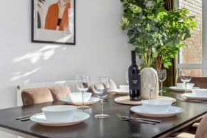 ein Esstisch mit Gläsern und einer Flasche Wein in der Unterkunft NEW Canalside House / 3 Bedroom House in Stoke-on-Trent in Stoke on Trent