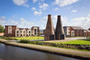eine Häuserreihe mit drei Schornsteinen neben einem Fluss in der Unterkunft NEW Canalside House / 3 Bedroom House in Stoke-on-Trent in Stoke on Trent + 29 Fotos