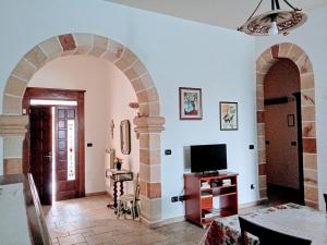 a living room with an archway and a television at La Rosa Blu in Copertino