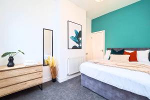 a bedroom with a bed and a blue wall at Penkhull House by Truestays - 4 Bedroom House in Stoke-on-Trent in Stoke on Trent