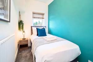 a bedroom with a bed with a blue wall at Penkhull House by Truestays - 4 Bedroom House in Stoke-on-Trent in Stoke on Trent