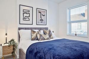 a bedroom with a blue bed with three pictures on the wall at Nursery House by Truestays - 3 Bedroom House in Stoke-on-Trent in Stoke on Trent