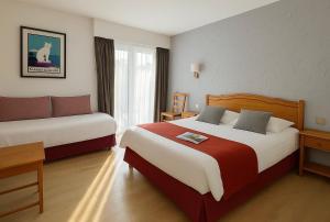 Postel nebo postele na pokoji v ubytování LOGIS HÔTEL, CHALETS et RESTAURANT LES CHATELMINÉS