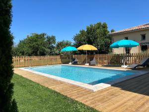 basen z 2 parasolami i 2 krzesłami w obiekcie Gite campagne - Vue Pyrénées - Piscine w mieście Sajas